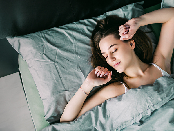Multiple sleeping figures shown on dark bedding, demonstrating comfortable sleeping positions.