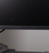 partial view of a speaker cone and a desktop computer screen