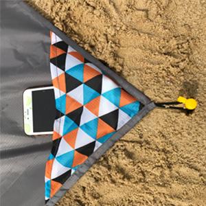 Compact pocket blanket with corner stakes and sand pockets for windy beach days and camping.