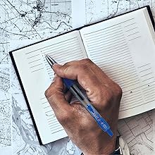 Photo shows person writing in travel planner with G2 pen