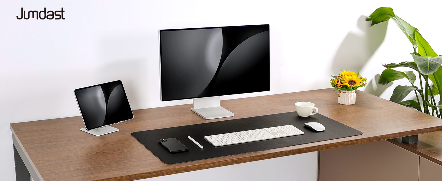 Desktop workspace setup showing a monitor, keyboard, and desk arrangement with plants and office accessories in a clean, modern style.