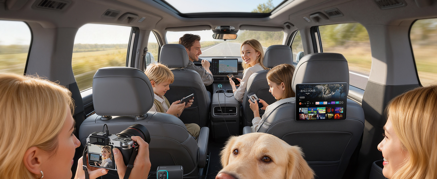 Interior view of vehicle showing backseat entertainment systems mounted on headrests. Golden retriever visible in passenger area. Vehicle appears to be on a road trip setting.