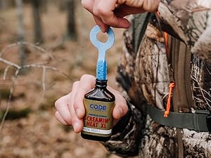 Man dipping an expandable wick into a bottle of Code Blue Screamin' Heat XL urine