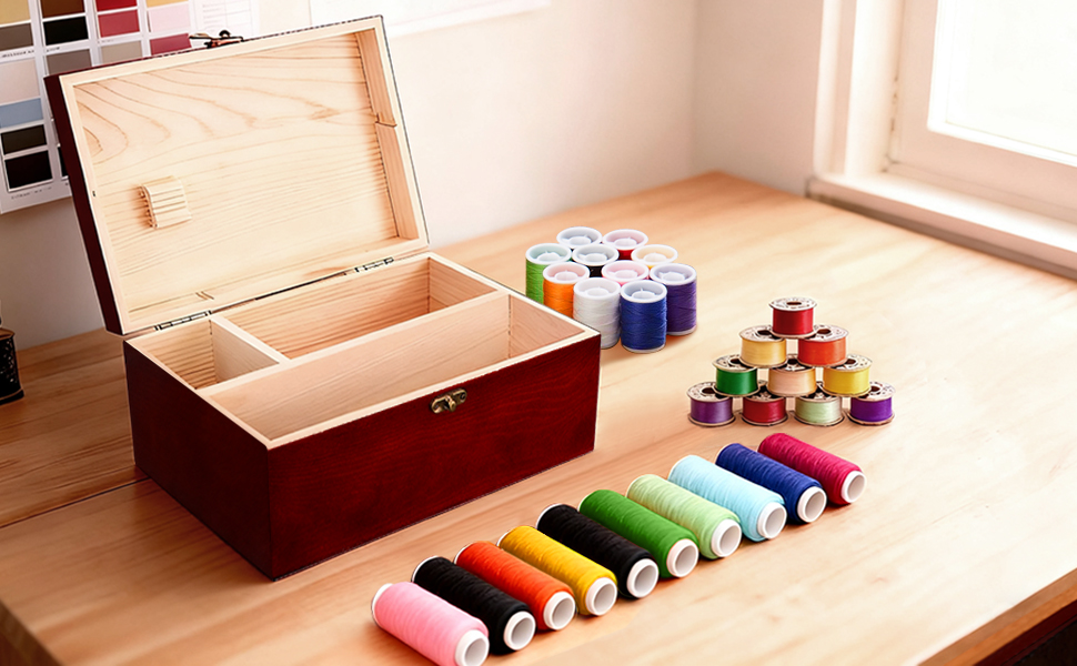 Display of a red wooden sewing box and sewing thread.