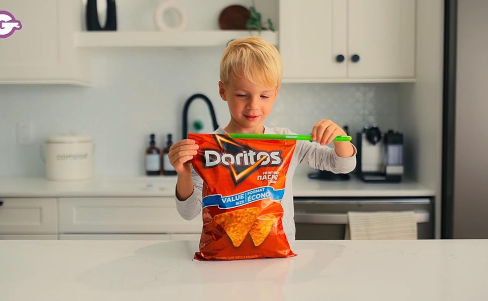 Young boy sliding a GripStic across a Doritos bag