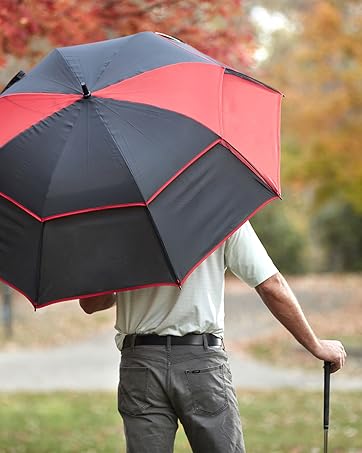 man holding umbrella with back turned. Outside with golf club