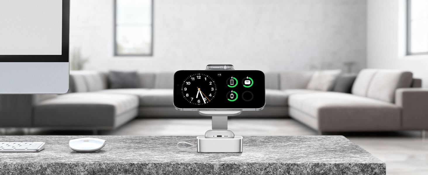 Modern living room with grey modular sofa, white coffee table, and black digital clock/display device on table showing green numbers and indicators.