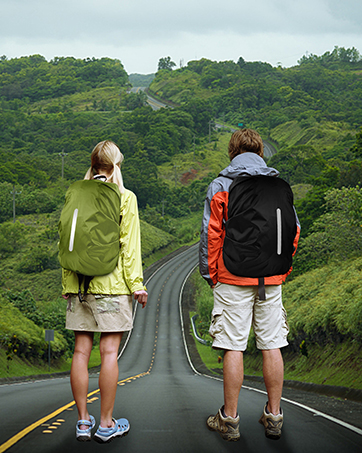 two people with backpacks standing on a road