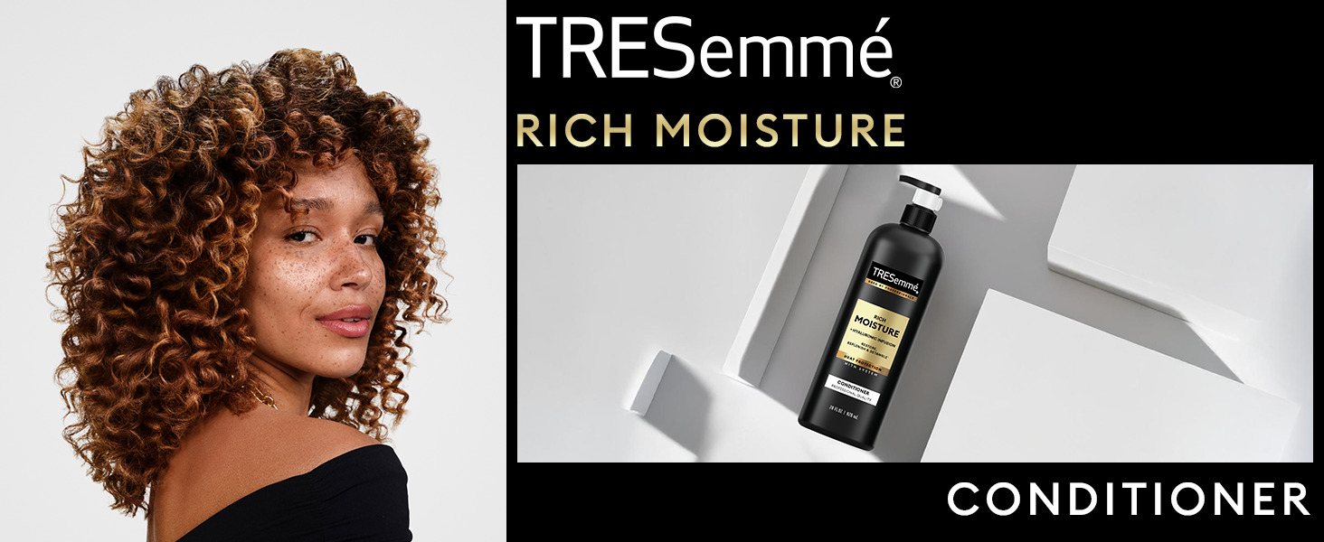Model with bouncy curls beside TRESemmé Conditioner on top of a geometrical, sleek surface.