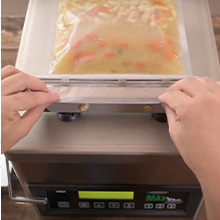 LEM vacuum sealer with a bag being sealed for food storage