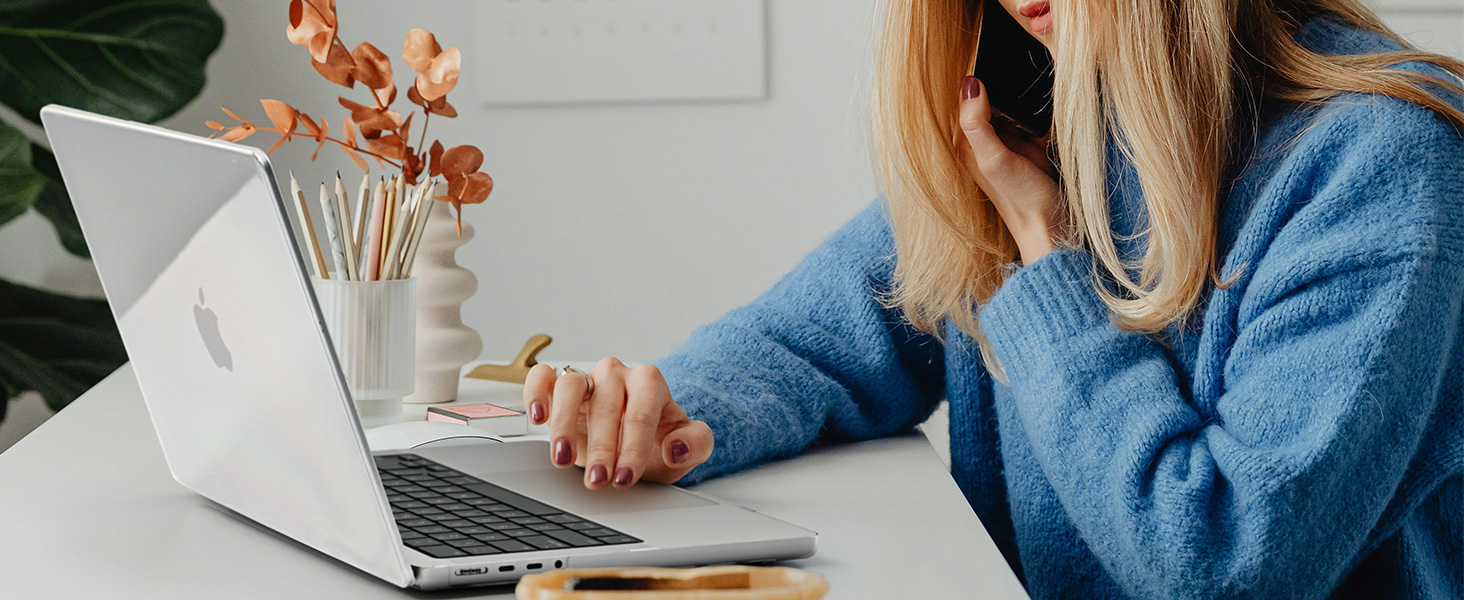 woman using a laptop and talking on a cell phone