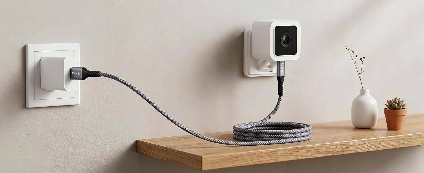 Long Micro USB power cord for Wyze Cam and Blink home security cameras on minimalist wall shelf.