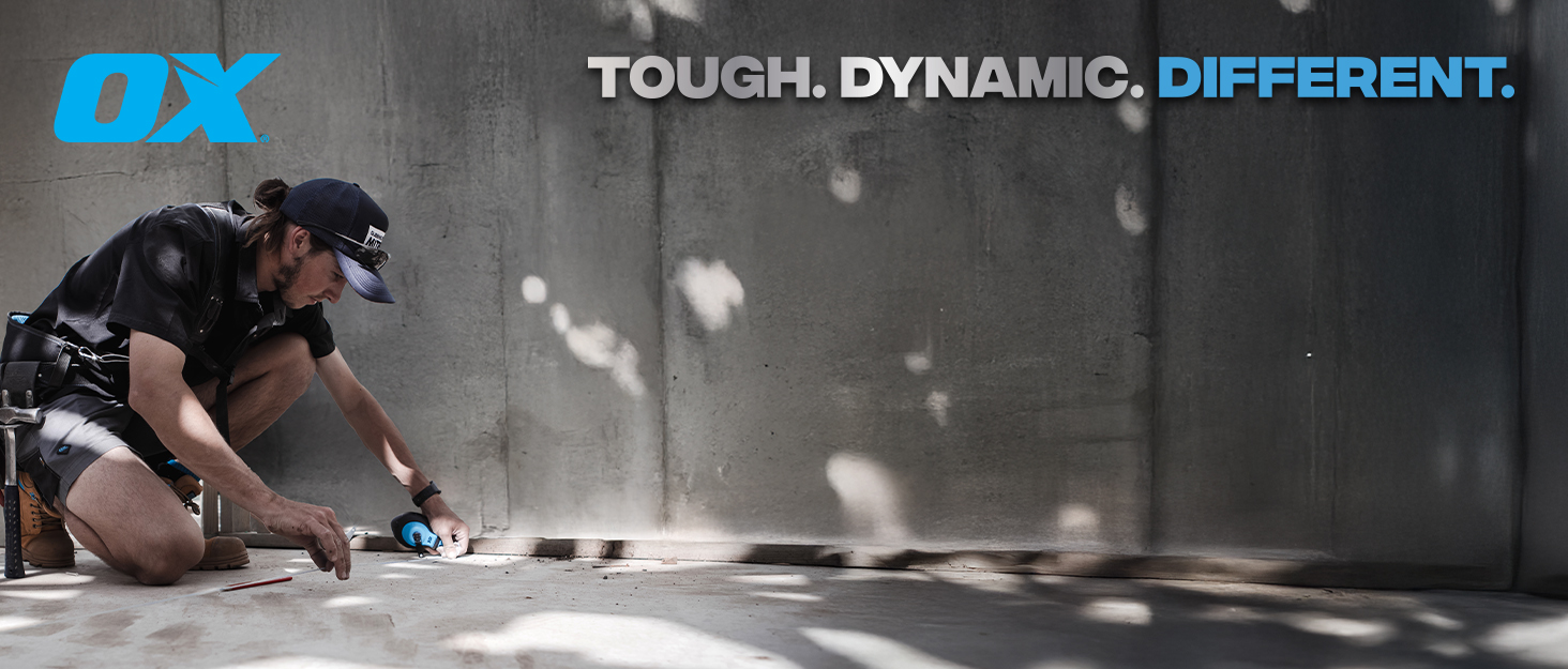 Contractor using an OX chalk reel with a OX logo and slogan: Tough. Dynamic. Different.