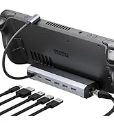 Handheld gaming device connected to a multi-port hub. Hub features HDMI, multiple USB ports, and power input. Several USB cables are shown connected to the hub.