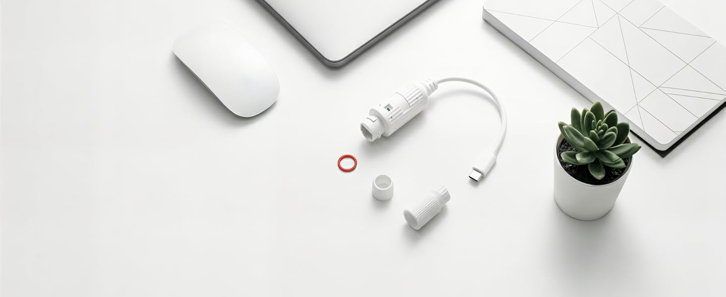 Flat lay composition showing white computer accessories: mouse, keyboard, charging cable with USB connector, earbuds, and small potted succulent plant on white surface.