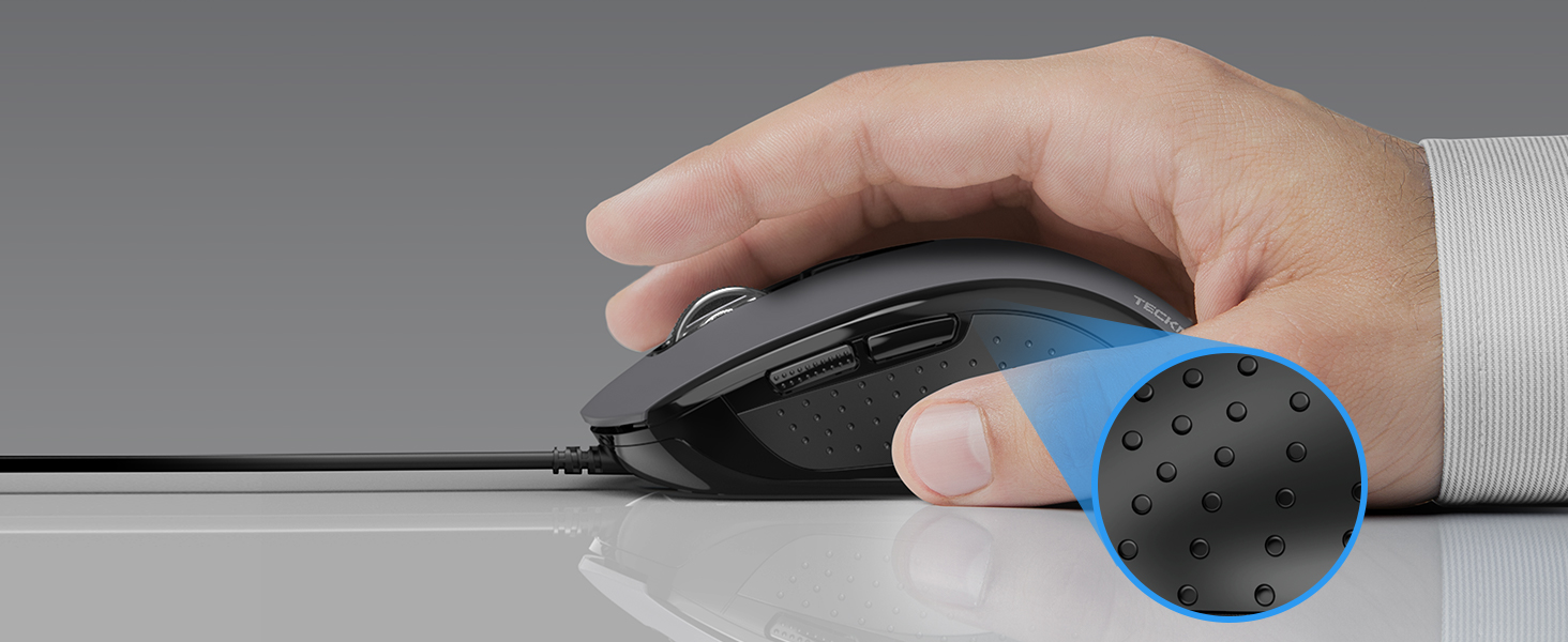 a hand holding a mouse on a desk.