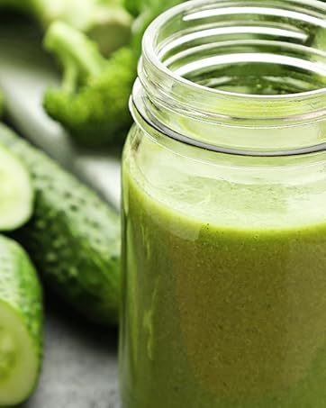 a glass jar filled with a green smoothie.
