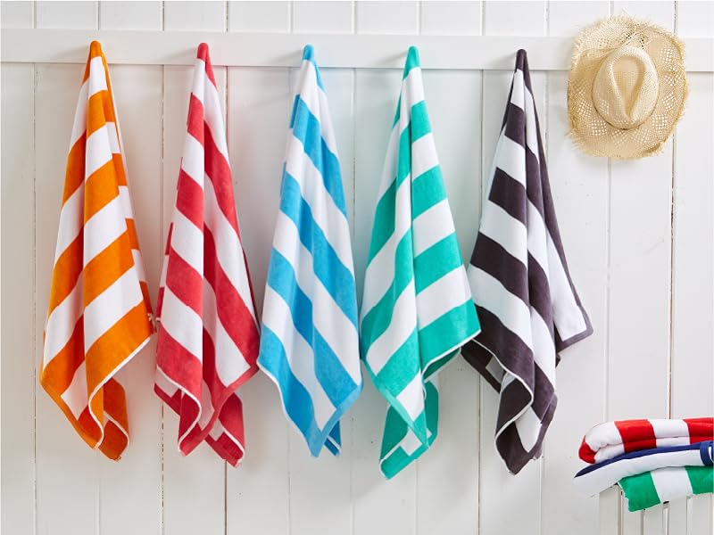 hanging cabana striped towels in a variety of colors on a beach wall