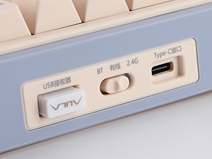 Close-up of electronic device interface showing USB-C port, power button, and LED indicator on a pale blue casing.