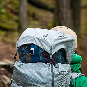 BV ONE straped to top of backpack walking on a forest trail