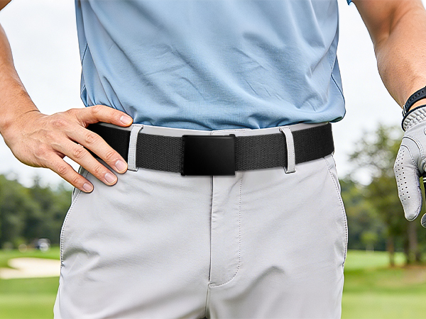 Close-up of person wearing light gray/white shorts with black belt and blue shirt, demonstrating mid-length shorts fit and styling on adult wearer outdoors.