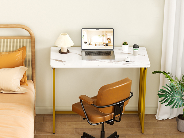 By the bed, a folding table and armchair sit near white curtains with a potted plant below