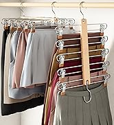 Multiple skirts hung on clear plastic hangers with clips, arranged on a wooden rod. Colors include black, gray, pink, and burgundy.