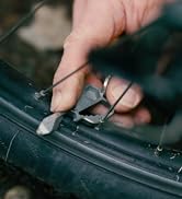 geekey multitool used as bike spoke key on bike tire to fix bike