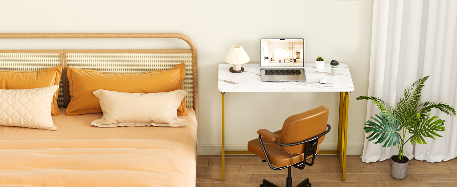By the bed, a folding table and armchair sit near white curtains with a potted plant below