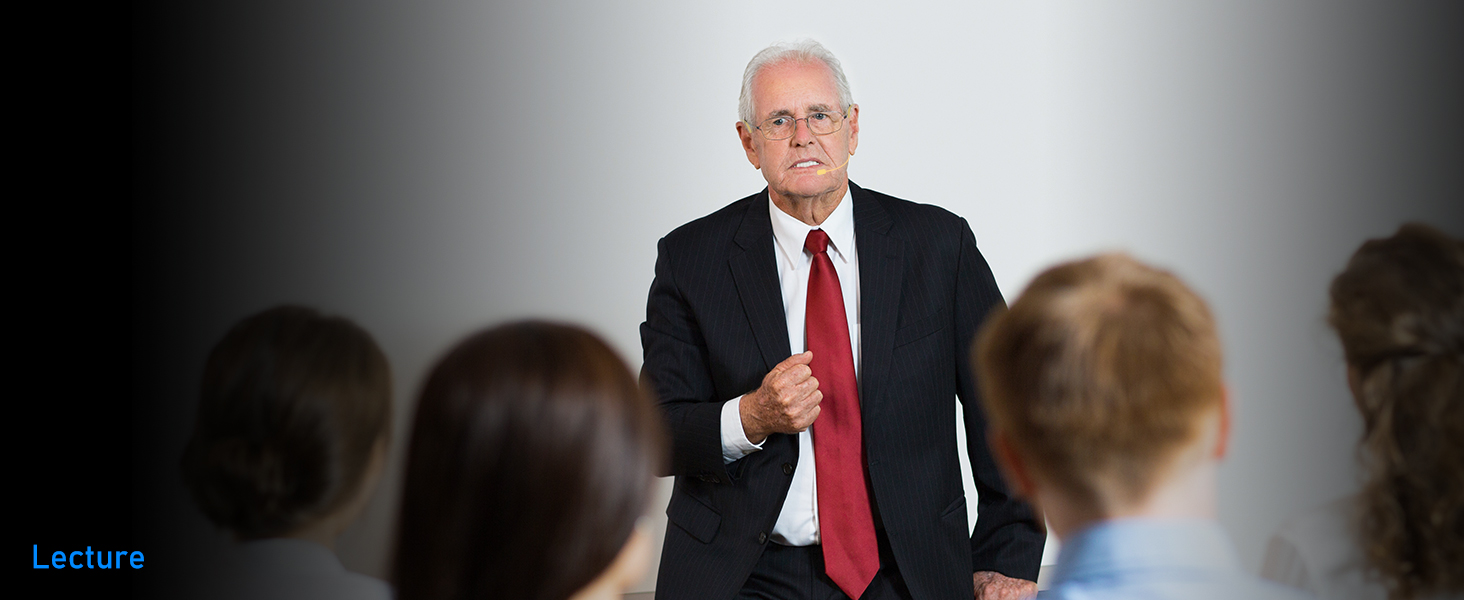 Professional presentation setup in a lecture hall showing audience members seated in rows facing front.