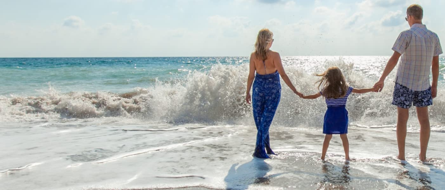 a mother and daughter walking on the beach