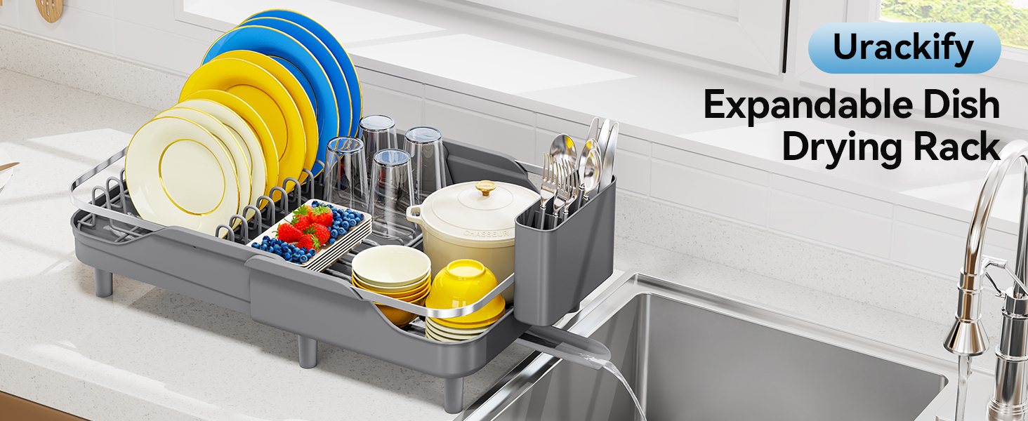 Text reads 'Urackify Expandable Dish Drying Rack'. Dark expandable dish rack with blue, yellow, and multicolored utensil holders displayed in kitchen sink area.