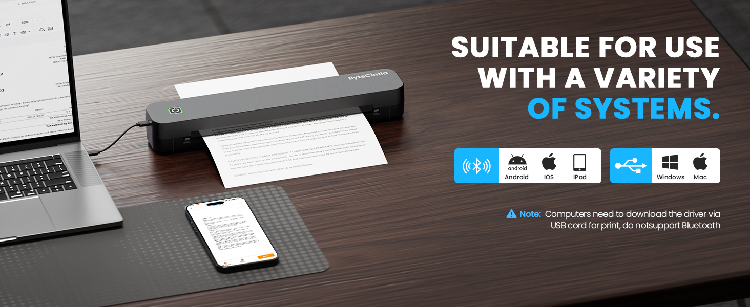 Text reads 'SUITABLE FOR USE WITH A VARIETY OF SYSTEMS.' Office desk setup showing laptop, smartphone and other devices in dark lighting
