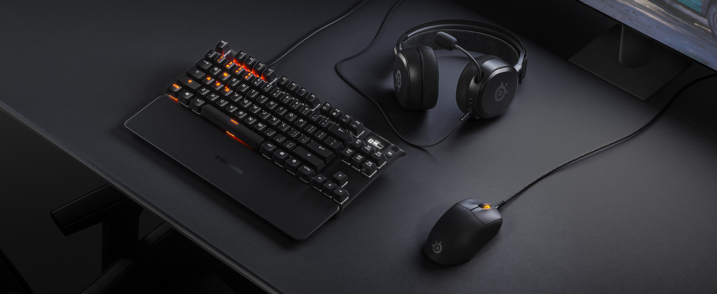 -SteelSeries desk setup with mousepad, keyboard, mouse, and headset