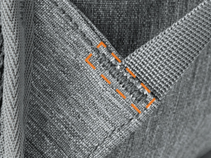 Close-up of gray fabric with visible weave pattern. Text 'POINTS PER INCH' partially visible, suggesting it relates to fabric quality or manufacturing specifications.