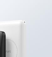 Partial view of white electronic device with curved edges. Portion of black device visible. Clean, minimalist design against white background.