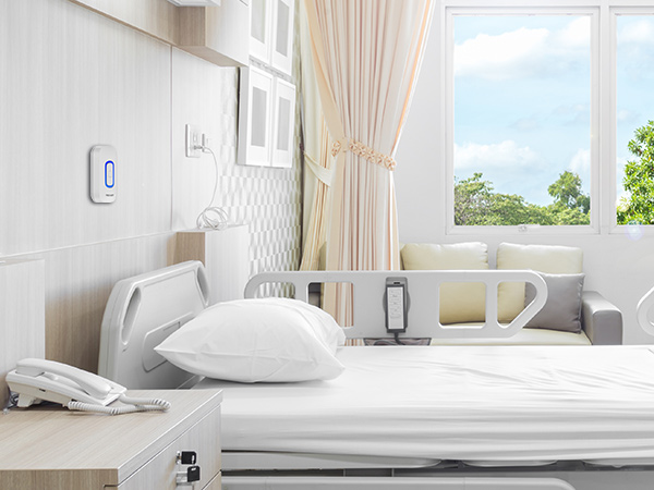 Clean, bright bedroom interior with white bedding and wall-mounted device, featuring natural light from window and beige curtains.