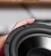 partial view of a hand holding a speaker