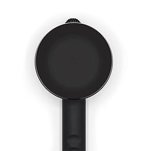 Top-down view of a black frying pan or cooking vessel with a long handle, photographed against a white background.