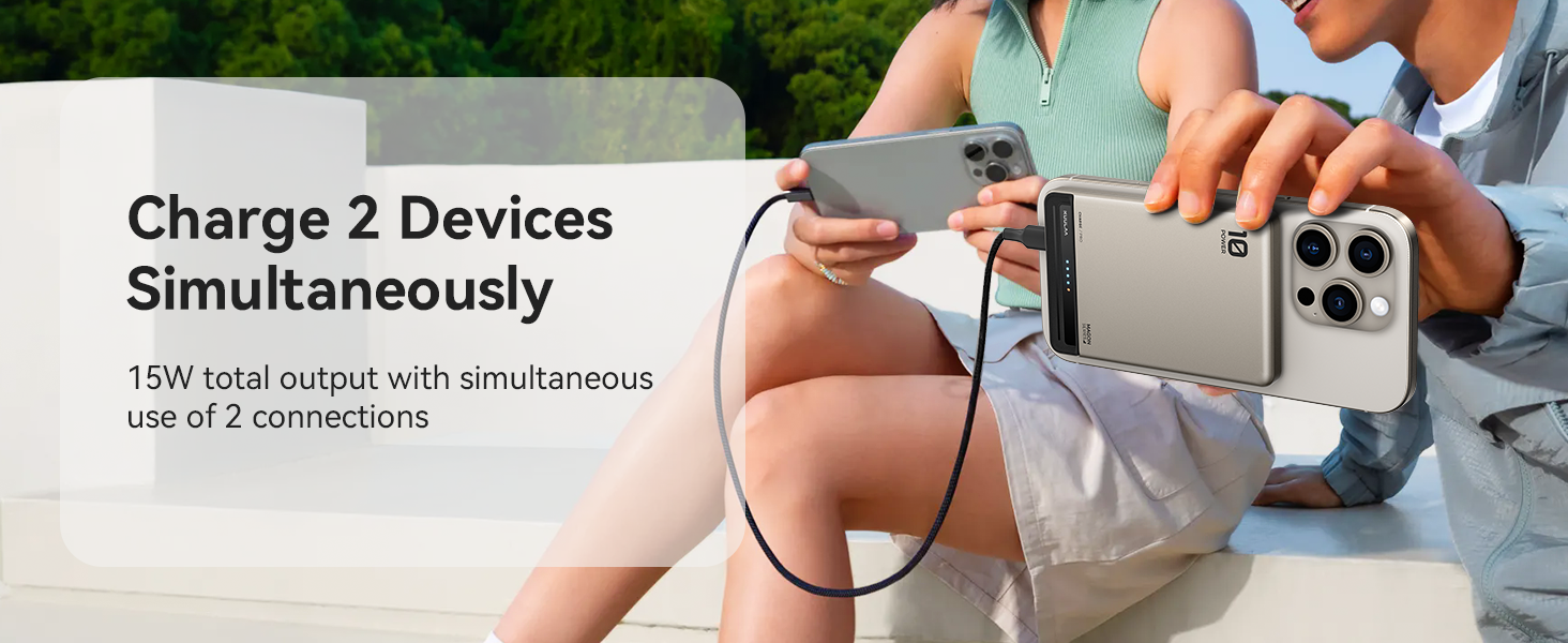 Portable charger powering two smartphones simultaneously. Device has 15W total output. People shown using the charger outdoors.