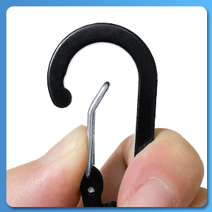 Small black plastic hook with metal tip being held between thumb and forefinger, demonstrating its size and flexibility.