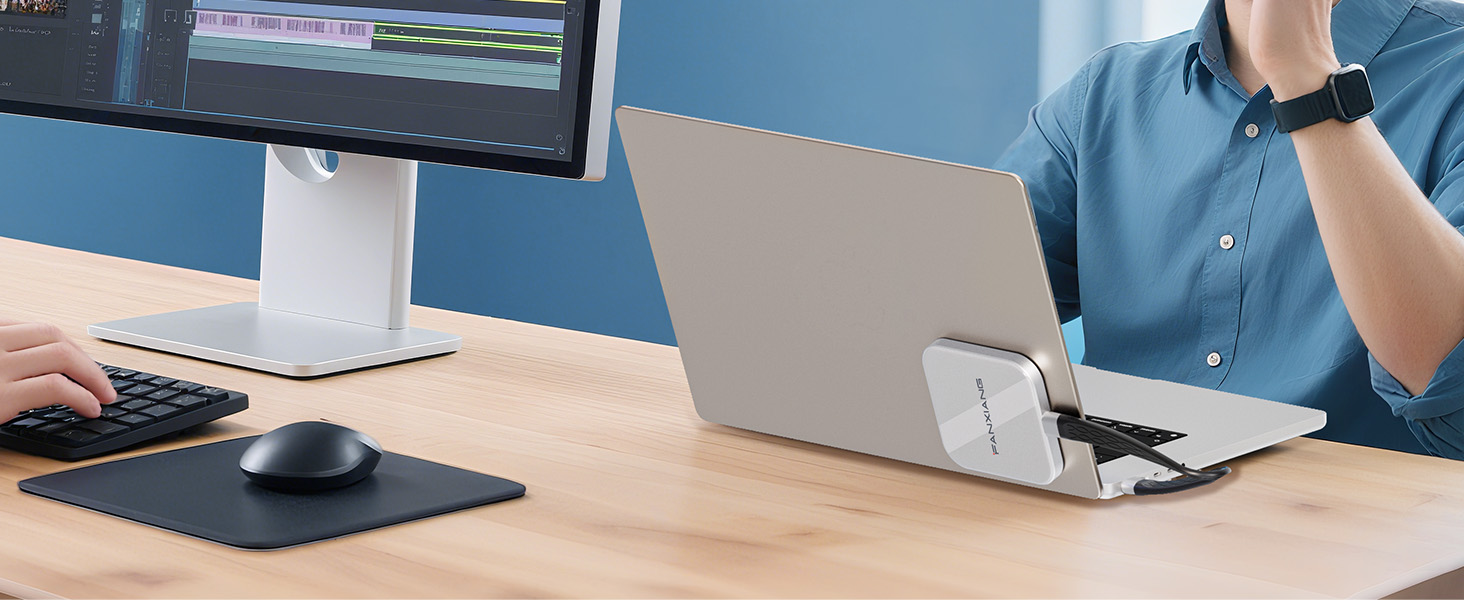 Modern office workspace with multiple computer monitors and laptops on wooden desks. People working in collaborative environment with clean, professional setup.