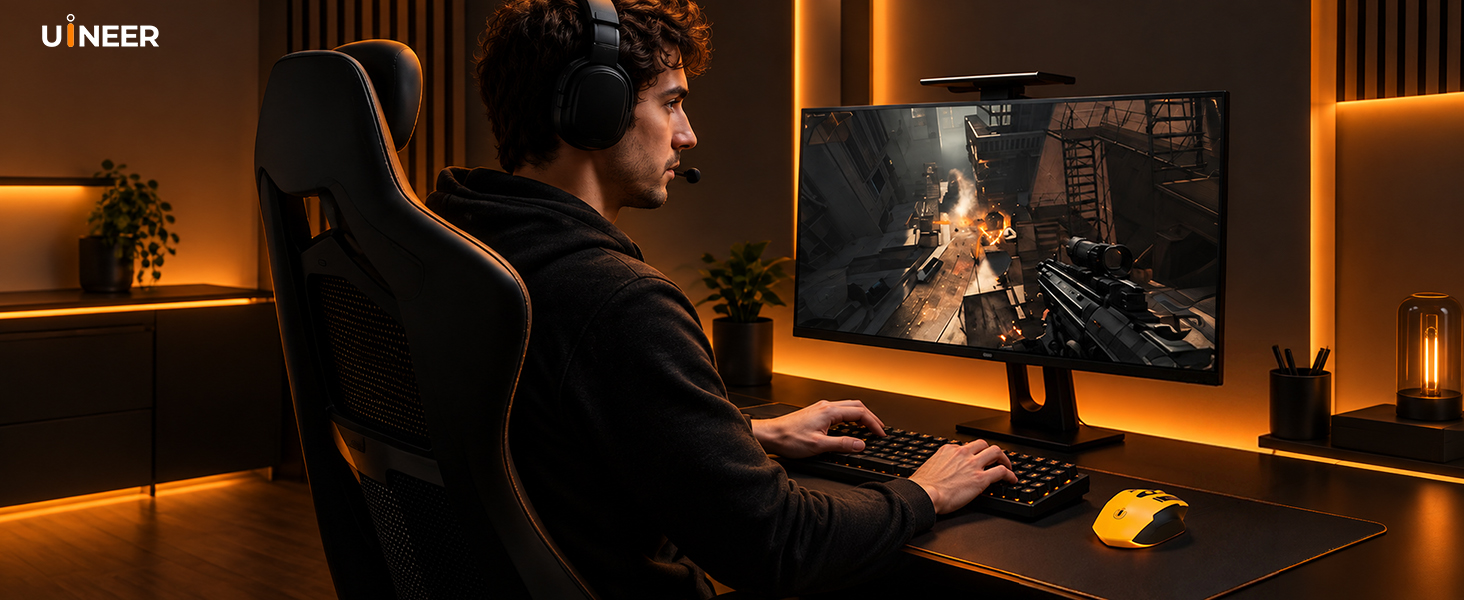 Person seated at computer workstation with monitor displaying fireplace scene, warm overhead lighting, dark background with ambient glow.