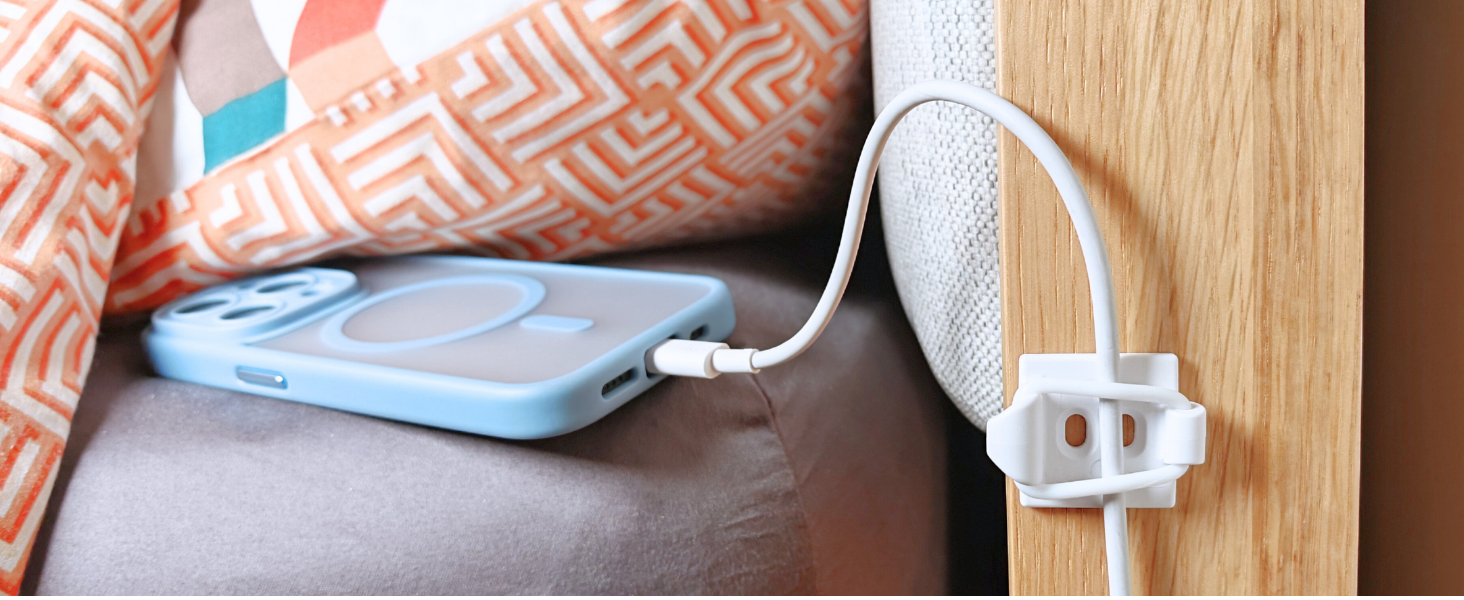 Phone charging cable secured by bed.