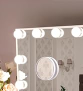 Partial view of a vanity mirror with bright round bulbs along the top edge. White-framed circular mirror visible in the center.
