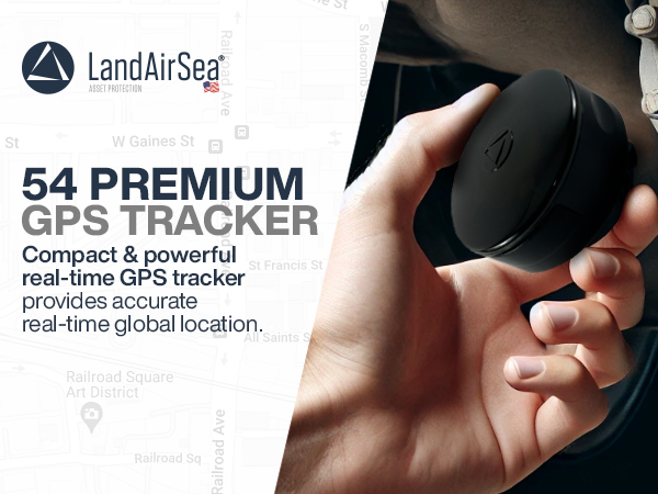 A man’s hand is holding a LandAirSea 54 compact GPS tracker and is about to place it under a car.