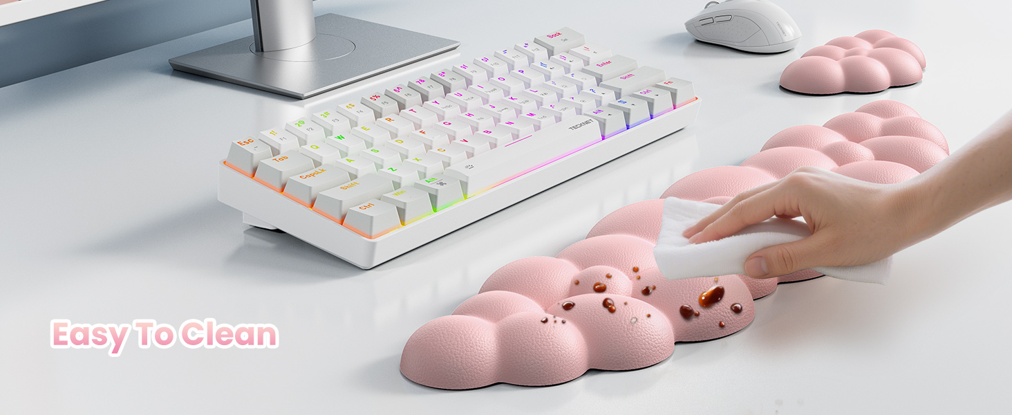 White mechanical keyboard with RGB lighting next to pink cloud-shaped stress relief toys. Hand demonstrating squeezing one of the toys. Text overlay reads 'Easy To Clean'.