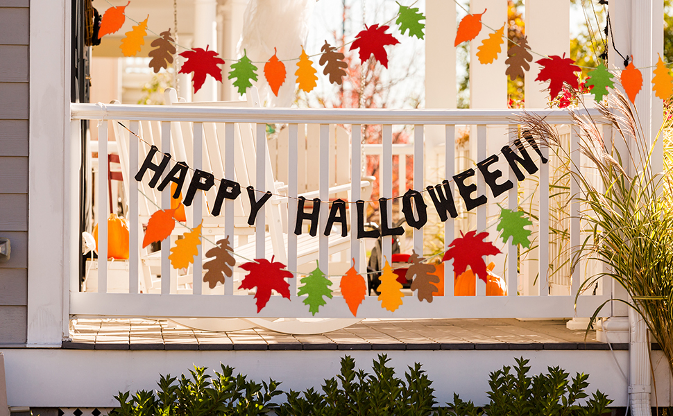 Text reads 'HAPPY HALLOWEEN' on black banner hanging across white porch railing, decorated with autumn maple leaves in orange and red colors.