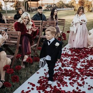 Ring bearer walking down the aisle holding a ring security case