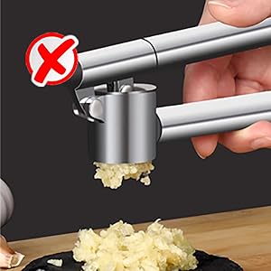 Stainless steel garlic press demonstration with 'X' warning symbol, showing incorrect pressing technique with garlic visible in chamber.